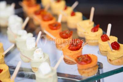 Mousse orange servie dans un verre, décorée d'un physalis et d'un segment de pamplemousse, posée sur une napperon blanc.