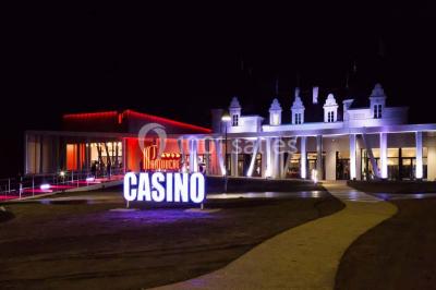 Mousse orange servie dans un verre, décorée d'un physalis et d'un segment de pamplemousse, posée sur une napperon blanc.