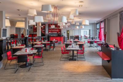 Mousse orange servie dans un verre, décorée d'un physalis et d'un segment de pamplemousse, posée sur une napperon blanc.