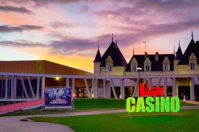 Mousse orange servie dans un verre, décorée d'un physalis et d'un segment de pamplemousse, posée sur une napperon blanc.