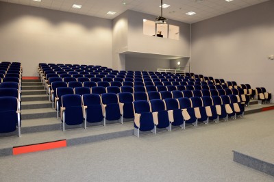 Salle aménagée avec des tables hautes et des comptoirs colorés, éclairée par des lumières chaleureuses.