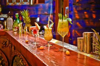 Vue nocturne d'un complexe de loisirs avec piscine illuminée, bâtiments thématiques et paysage urbain en arrière-plan.