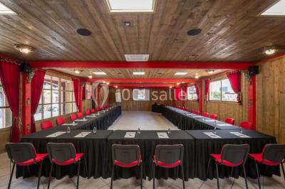 Vue nocturne d'un complexe de loisirs avec piscine illuminée, bâtiments thématiques et paysage urbain en arrière-plan.