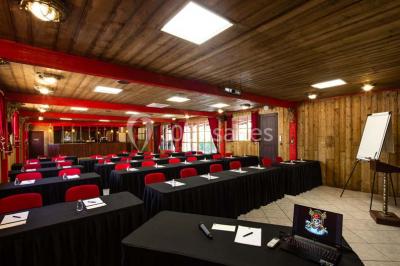 Vue nocturne d'un complexe de loisirs avec piscine illuminée, bâtiments thématiques et paysage urbain en arrière-plan.