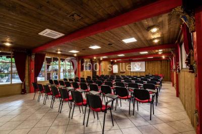 Vue nocturne d'un complexe de loisirs avec piscine illuminée, bâtiments thématiques et paysage urbain en arrière-plan.