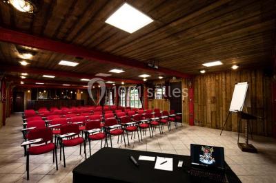 Vue nocturne d'un complexe de loisirs avec piscine illuminée, bâtiments thématiques et paysage urbain en arrière-plan.