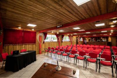 Vue nocturne d'un complexe de loisirs avec piscine illuminée, bâtiments thématiques et paysage urbain en arrière-plan.