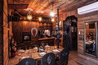 Vue nocturne d'un complexe de loisirs avec piscine illuminée, bâtiments thématiques et paysage urbain en arrière-plan.