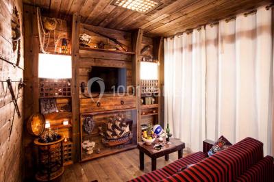 Vue nocturne d'un complexe de loisirs avec piscine illuminée, bâtiments thématiques et paysage urbain en arrière-plan.