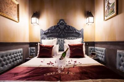 Vue nocturne d'un complexe de loisirs avec piscine illuminée, bâtiments thématiques et paysage urbain en arrière-plan.