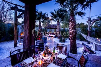 Vue nocturne d'un complexe de loisirs avec piscine illuminée, bâtiments thématiques et paysage urbain en arrière-plan.