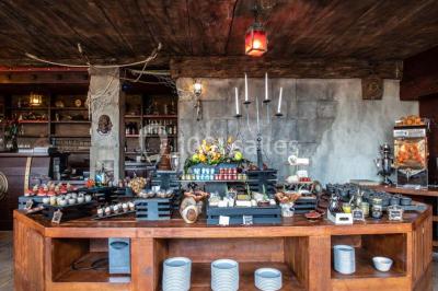 Vue nocturne d'un complexe de loisirs avec piscine illuminée, bâtiments thématiques et paysage urbain en arrière-plan.