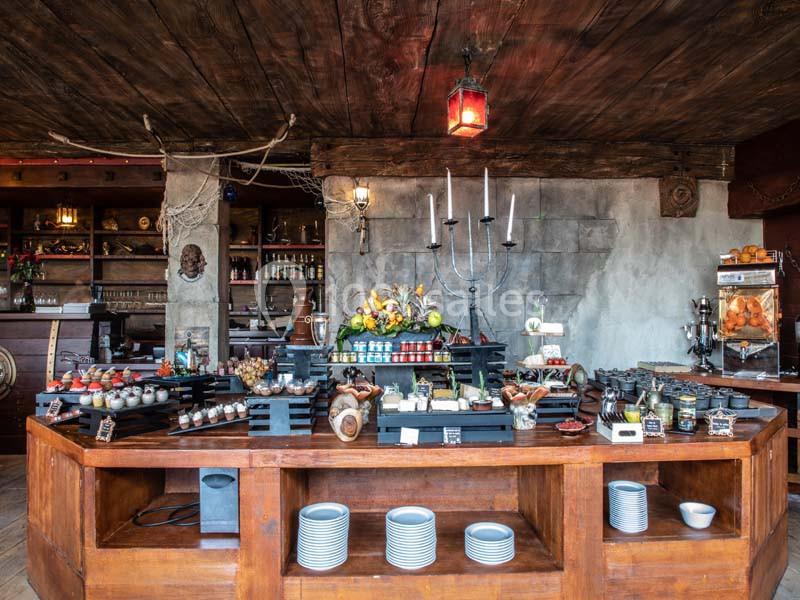 Buffet varié présenté sur un comptoir en bois dans un décor rustique avec éclairage chaleureux.