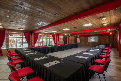 Vue nocturne d'un complexe de loisirs avec piscine illuminée, bâtiments thématiques et paysage urbain en arrière-plan.