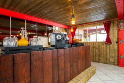 Vue nocturne d'un complexe de loisirs avec piscine illuminée, bâtiments thématiques et paysage urbain en arrière-plan.