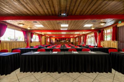 Vue nocturne d'un complexe de loisirs avec piscine illuminée, bâtiments thématiques et paysage urbain en arrière-plan.