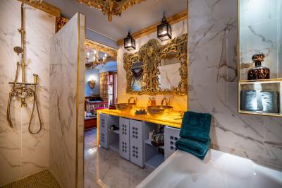 Vue nocturne d'un complexe de loisirs avec piscine illuminée, bâtiments thématiques et paysage urbain en arrière-plan.