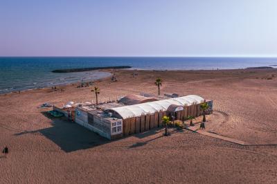 Vue nocturne d'un complexe de loisirs avec piscine illuminée, bâtiments thématiques et paysage urbain en arrière-plan.