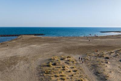 Vue nocturne d'un complexe de loisirs avec piscine illuminée, bâtiments thématiques et paysage urbain en arrière-plan.