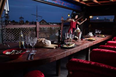 Vue nocturne d'un complexe de loisirs avec piscine illuminée, bâtiments thématiques et paysage urbain en arrière-plan.