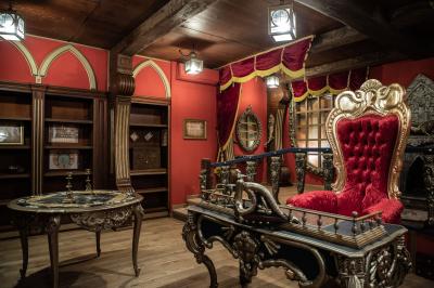 Vue nocturne d'un complexe de loisirs avec piscine illuminée, bâtiments thématiques et paysage urbain en arrière-plan.