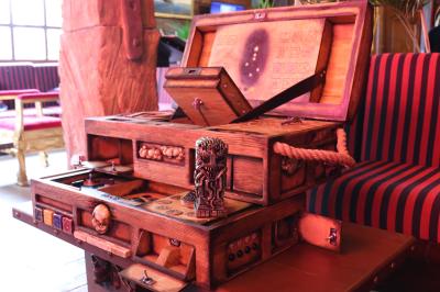 Vue nocturne d'un complexe de loisirs avec piscine illuminée, bâtiments thématiques et paysage urbain en arrière-plan.