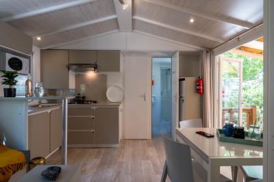 Vue nocturne d'un complexe de loisirs avec piscine illuminée, bâtiments thématiques et paysage urbain en arrière-plan.