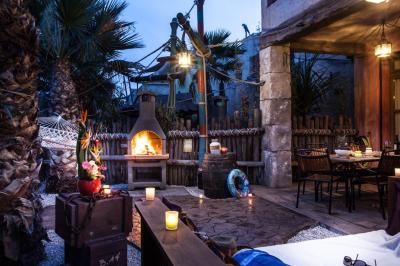 Vue nocturne d'un complexe de loisirs avec piscine illuminée, bâtiments thématiques et paysage urbain en arrière-plan.