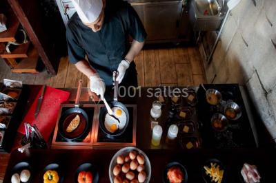 Vue nocturne d'un complexe de loisirs avec piscine illuminée, bâtiments thématiques et paysage urbain en arrière-plan.