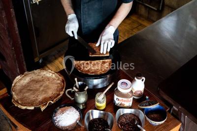 Vue nocturne d'un complexe de loisirs avec piscine illuminée, bâtiments thématiques et paysage urbain en arrière-plan.