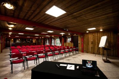 Vue nocturne d'un complexe de loisirs avec piscine illuminée, bâtiments thématiques et paysage urbain en arrière-plan.