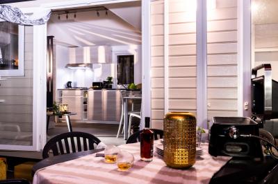 Vue nocturne d'un complexe de loisirs avec piscine illuminée, bâtiments thématiques et paysage urbain en arrière-plan.