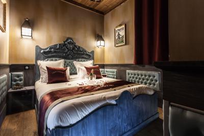 Vue nocturne d'un complexe de loisirs avec piscine illuminée, bâtiments thématiques et paysage urbain en arrière-plan.