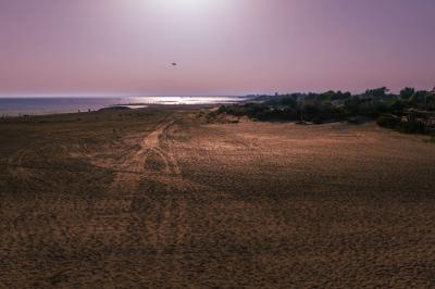 Vue nocturne d'un complexe de loisirs avec piscine illuminée, bâtiments thématiques et paysage urbain en arrière-plan.