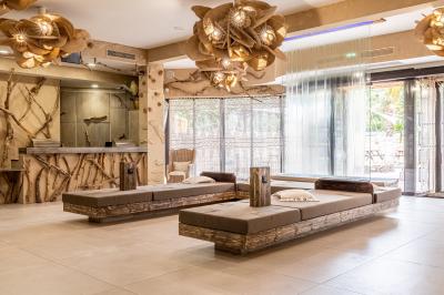 Vue nocturne d'un complexe de loisirs avec piscine illuminée, bâtiments thématiques et paysage urbain en arrière-plan.