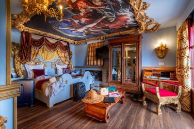 Vue nocturne d'un complexe de loisirs avec piscine illuminée, bâtiments thématiques et paysage urbain en arrière-plan.