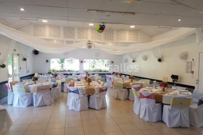Paysage champêtre avec un étang entouré d'arbres, une barrière en bois au premier plan et un ciel dégagé.
