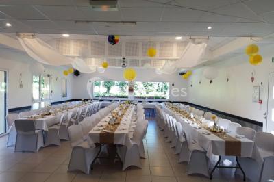 Paysage champêtre avec un étang entouré d'arbres, une barrière en bois au premier plan et un ciel dégagé.