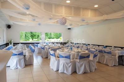 Paysage champêtre avec un étang entouré d'arbres, une barrière en bois au premier plan et un ciel dégagé.