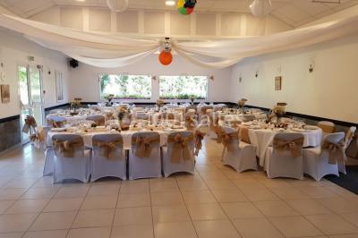 Paysage champêtre avec un étang entouré d'arbres, une barrière en bois au premier plan et un ciel dégagé.