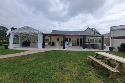 Paysage champêtre avec un étang entouré d'arbres, une barrière en bois au premier plan et un ciel dégagé.