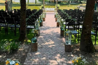 Miniature Location salle Romillé (Ille-et-Vilaine) - Domaine du Pont Sée #10 Allée extérieure pavée décorée pour une cérémonie, avec lanternes blanches ornées de fleurs jaunes et blanches.