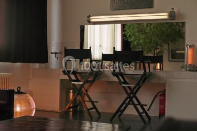 Espace intérieur lumineux avec un studio photo, canapé violet, table en bois et décoration moderne.