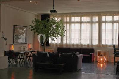 Espace intérieur lumineux avec un studio photo, canapé violet, table en bois et décoration moderne.