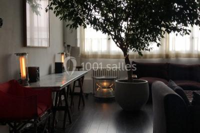 Espace intérieur lumineux avec un studio photo, canapé violet, table en bois et décoration moderne.