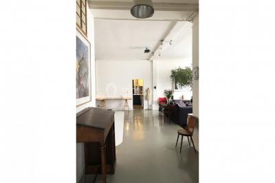 Espace intérieur lumineux avec un studio photo, canapé violet, table en bois et décoration moderne.