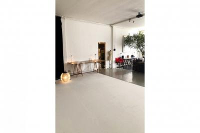 Espace intérieur lumineux avec un studio photo, canapé violet, table en bois et décoration moderne.