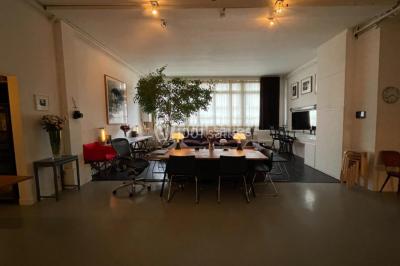 Espace intérieur lumineux avec un studio photo, canapé violet, table en bois et décoration moderne.