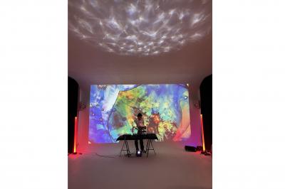 Espace intérieur lumineux avec un studio photo, canapé violet, table en bois et décoration moderne.