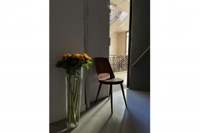 Espace intérieur lumineux avec un studio photo, canapé violet, table en bois et décoration moderne.